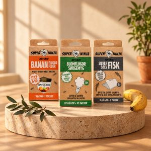 Super Ninja Bananflugefälla, Blomflugefälla 10-pack och Silverfiskfälla 3-pack på en stensockel i varmt eftermiddagsljus